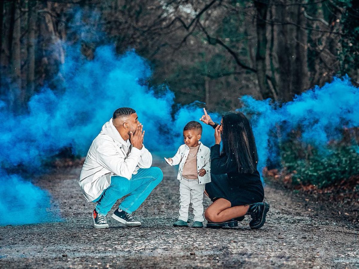 Parents and their young son celebrating a gender reveal with blue smoke after early gender testing at Surepointe Lab in Pharr, Texas